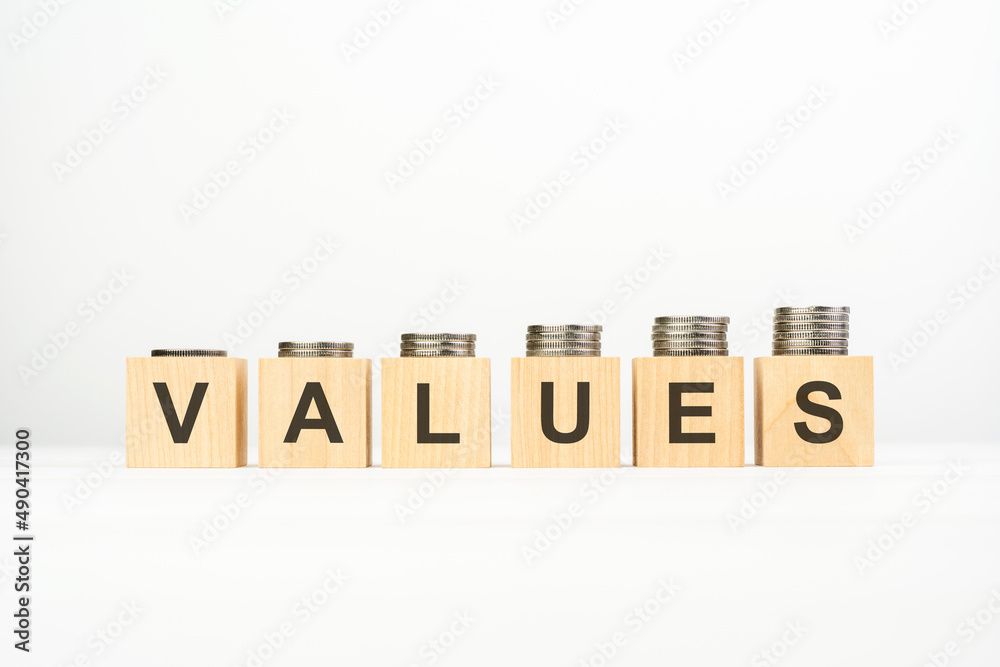 VALUES text written on wooden block with stacked coins on white background VALUES text written on wooden block with stacked coins on white background