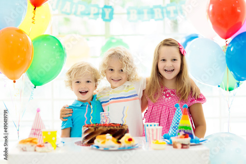 Kids birthday party. Child blowing out cake candle