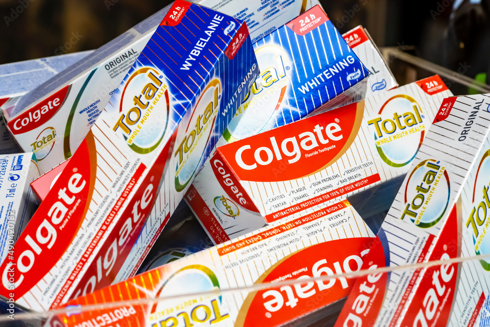 Lots of Colgate Total teeth whitening fluoride toothpaste packages, object closeup, nobody. Selling medical teeth care products, retail concept, no people