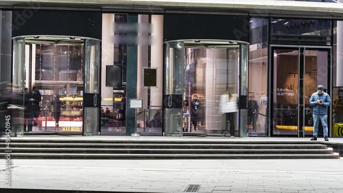The flow of people passing through the revolving door of the modern office building at the end of the working day,time lapse