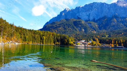 Fall in the forest. Gorgeous landscape  emerald green kristal clear lake  evergreen forest  mountain peack background  sunny day  blue sky. Hiking and relaxing in Bavarian Alps  Eibsee lake  Germany.