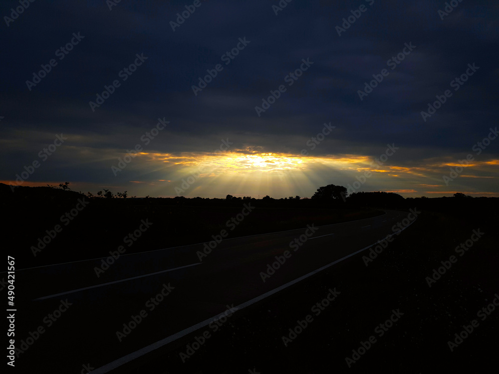  Sonnenuntergang, goldenes Sonnenstrahlen durch Wolken. Kinohimmel.  Bavaria, Bayern, Deutschland
