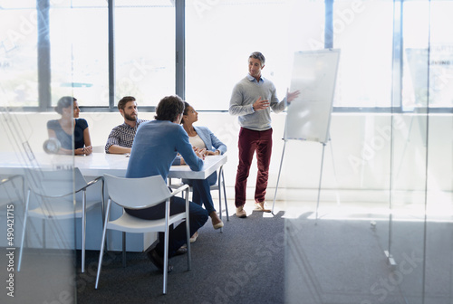 Starting the day with a strategizing session. A businessman doing a presentation using a whiteboard during a boardroom meeting.