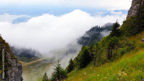 Geheimnisvolle Waldlandschaft und spektakuläres von Wolken bedeckter Berglandschaft . Kinohimmel voller flauschige Wolken. Bergwanderung in Bayern Alpen, Bavaria, Deutschland, Europe. 