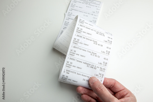 A long store receipt in hand, food expenditure analysis photo