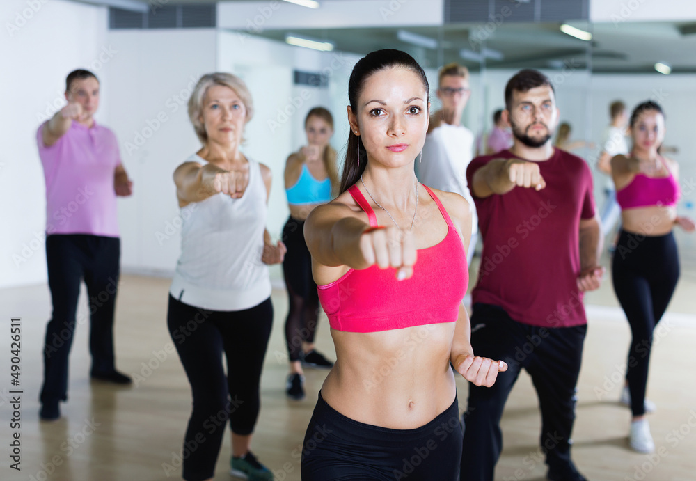 Happy cheerful slim athletic women and men dancing strip plastic in class