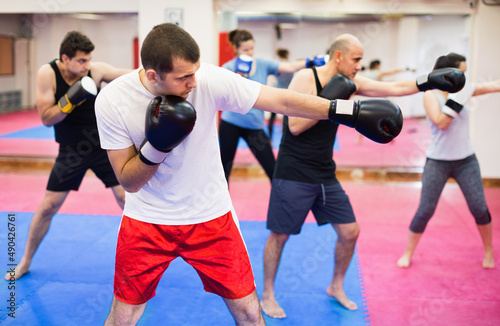 Portrait of pleasant females and adult males training in boxing gloves © JackF