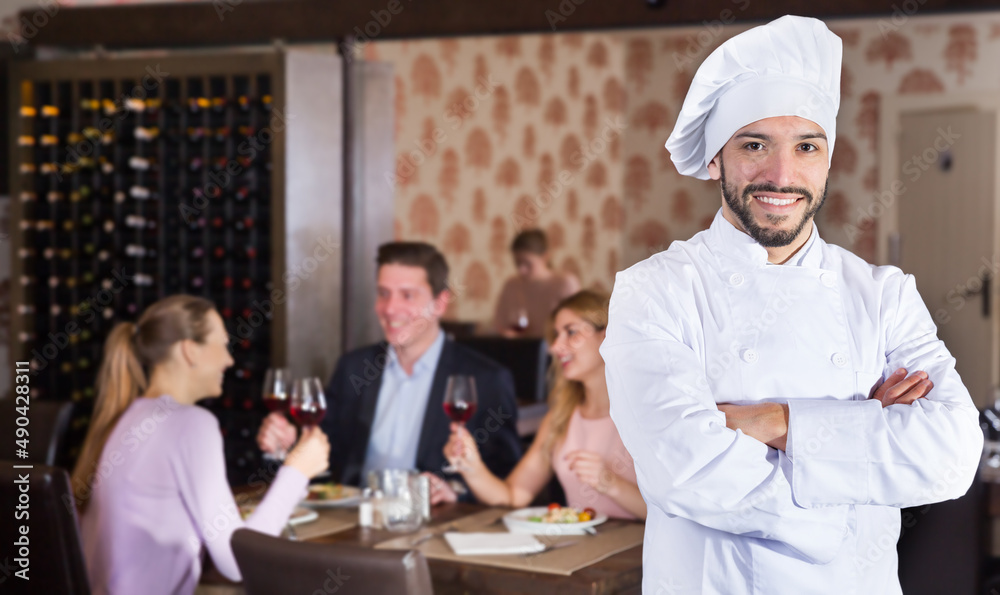 Portrait of confident smiling chef standing at restaurant hall