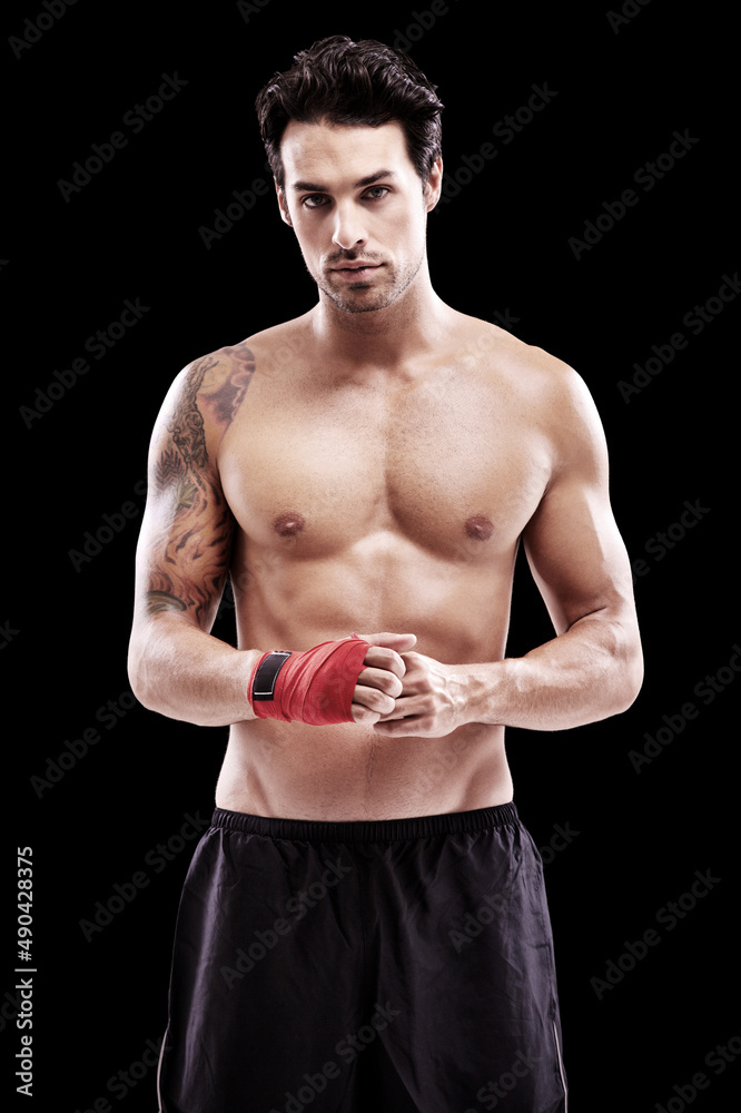 Hes prepared for battle. Studio portrait of a fit young man with wrapped fists isolated on black.