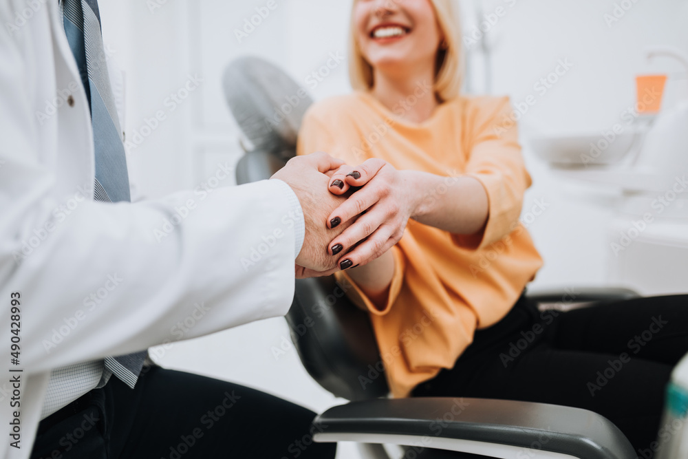 A young blonde woman talks with her dentist about dental treatment. A young blonde woman talks with her dentist about dental treatment.