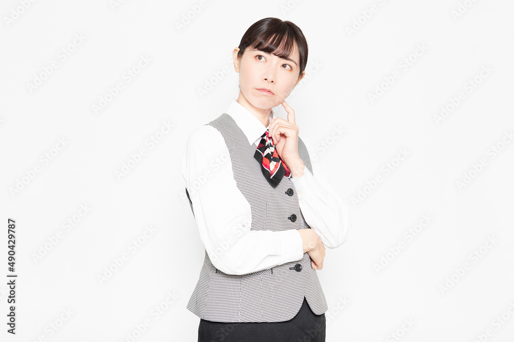 白背景の前に立って悩んでいる制服姿のビジネスウーマン 白背景の前に立って悩んでいる制服姿のビジネスウーマン