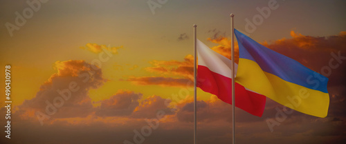 Panoramic sunset sky with Polish and Ukrainian Flags © bartsadowski