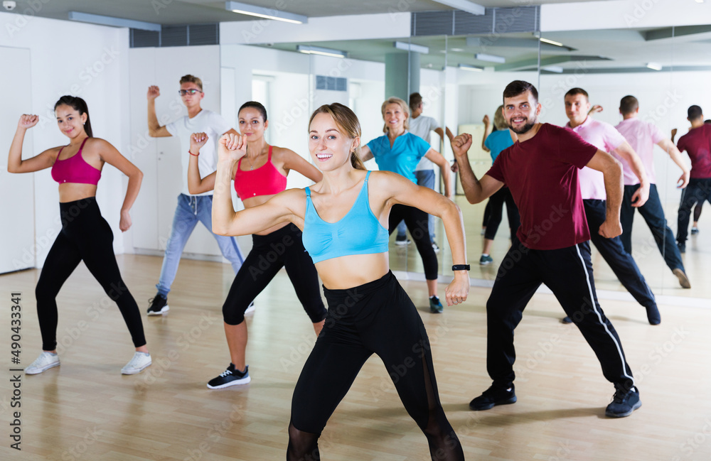 Fototapeta premium glad active sporty adults of different ages dancing at dance class
