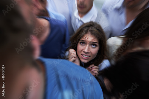Drowning in people. Shot of a fearful young woman feeling trapped by the crowd.
