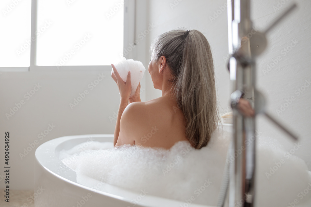 Beautiful adult woman relaxing in bathtube in spa Beautiful adult woman relaxing in bathtube in spa