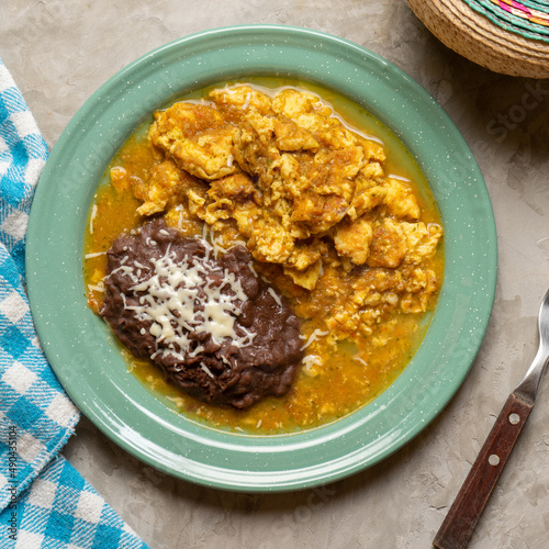 Scrambled eggs with red sauce and beans. Mexican food photo