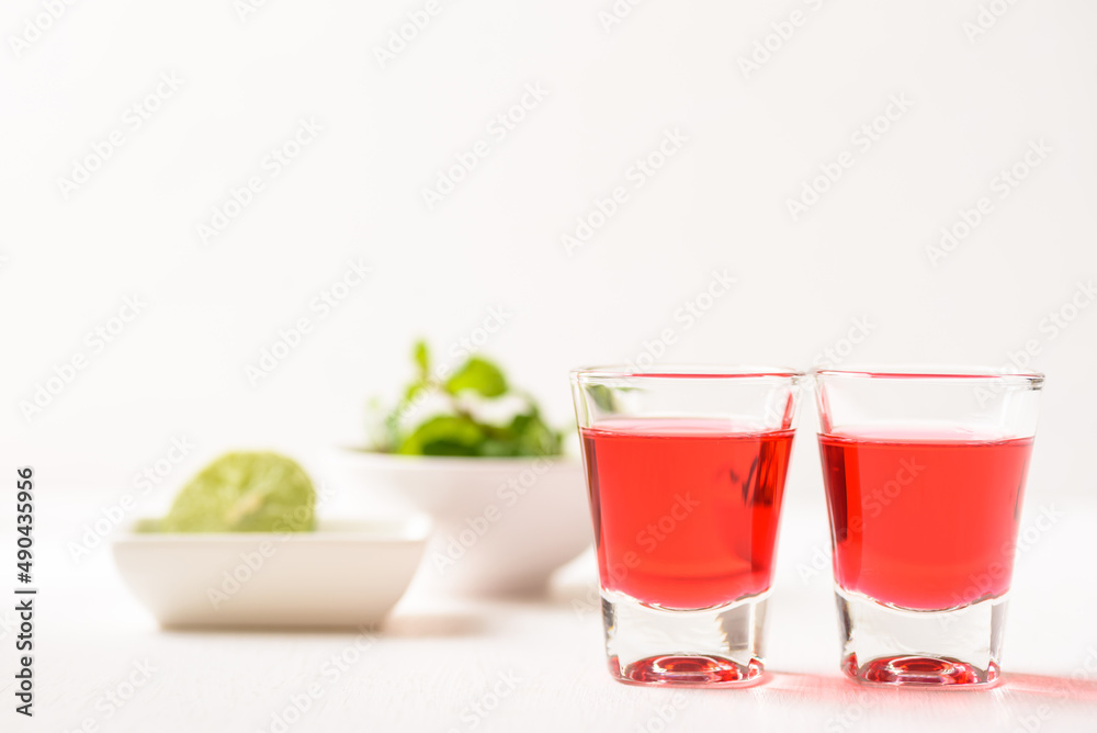 Red tequila with lime and mint on white background, Tropical spring and summer vacation concept Red tequila with lime and mint on white background, Tropical spring and summer vacation concept