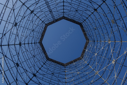 Uprisen angle view inside former gasometer, existing structure against blue sky. 