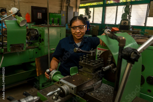 Latin young woman working on an industrial lathe as a symbol of female empowerment
