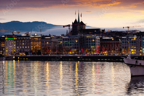 Photo of embankment in Geneva during evening with turned on city lights.