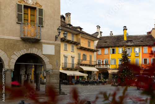 View of empty Piazza del Mercato in historical center of small Italian town of Domodossola with decorated Christmas tree on winter day photo