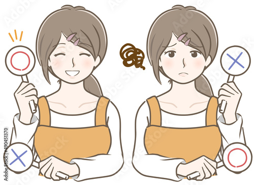 〇✕を持つエプロン姿の若い女性