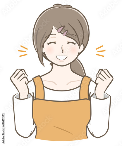 ガッツポーズをして喜ぶエプロン姿の若い女性