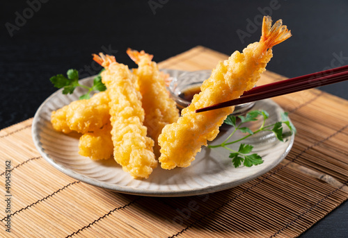 Shrimp tempura on a plate placed against a black background. photo