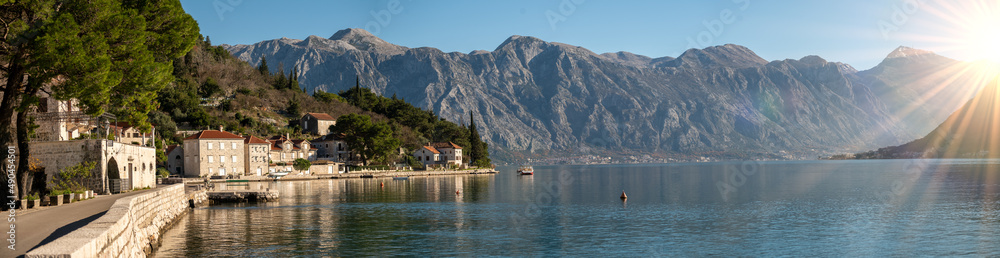 Perast, Montenegro and bay of Kotor. Scenic panorama view of historic town Perast at famous Bay of Kotor with blooming flowers on beautiful sunny day with blue sky in summer, panorama