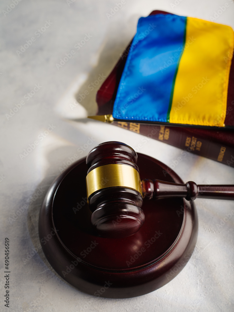 Judge's gavel on the book and the flag of Ukraine.Justice.The Hague court.Stop war and justice.Russian invasion.For news and media
