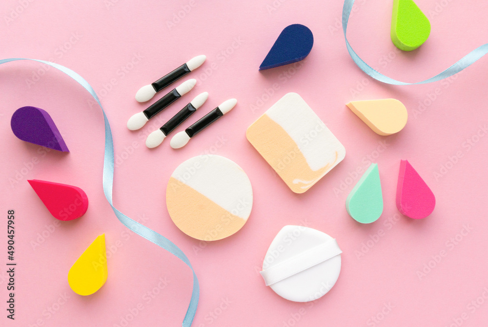 Makeup flat lay. Various foundation sponges and eyeshadow applicators on pink background Makeup flat lay. Various foundation sponges and eyeshadow applicators on pink background