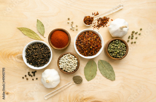 Different types of peppers in small bowls on wooden background  top view