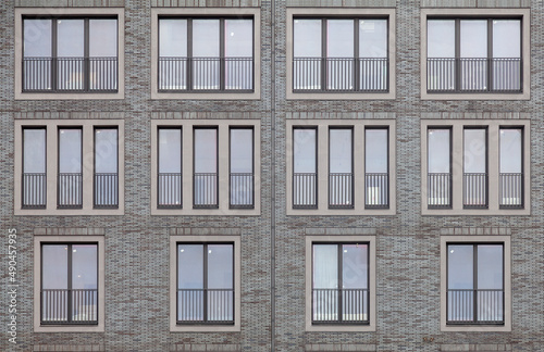 Background image - brick wall of a building with windows of different sizes