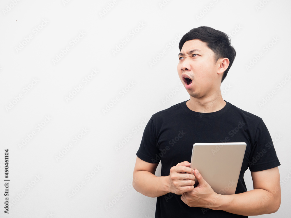 Man holding tablet feeling shocked looking at copy space
