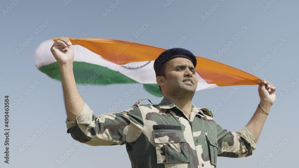 happy indian army soldier holding waving Indian flag in uniform - concept national pride, patriotism, freedom and independence