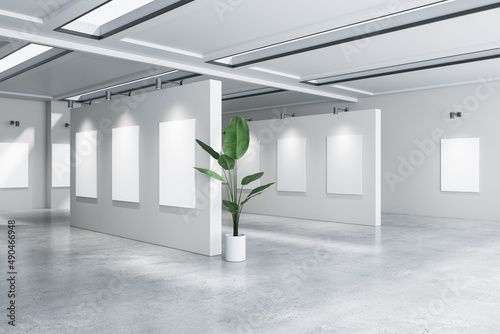 Modern concrete gallery interior with empty white mock up banners and decorative plant. Exhibition concept. 3D Rendering.