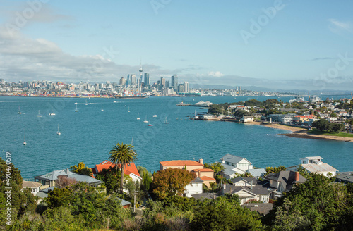 Auckland city line as seen from Devonport, North Head Historic Reserve. Sunny day, yachts on the water, roofs in the foreground.