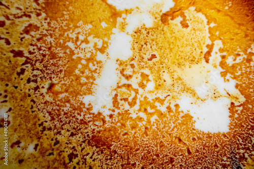 Abstract yellow-orange burning cream texture in white background. Milk burning pots orange-yellow texture. Abstract rustic texture. © Onuchcha