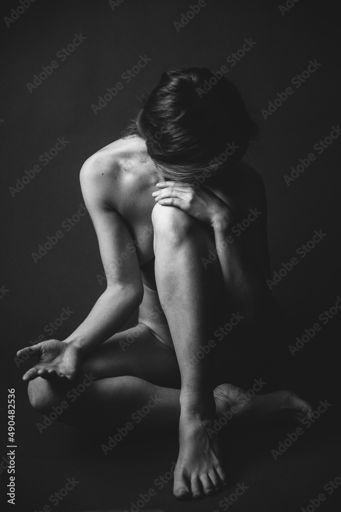 Black and white body, nude photo of a young girl, closed pose. Noisy frame on vintage film Black and white body, nude photo of a young girl, closed pose. Noisy frame on vintage film