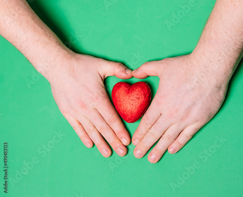 Fototapeta Naklejka Na Ścianę i Meble -  Hands hold a red heart, health insurance, charitable giving concept, world health day, world heart day, heart care, all lives matter concept, all lives matter