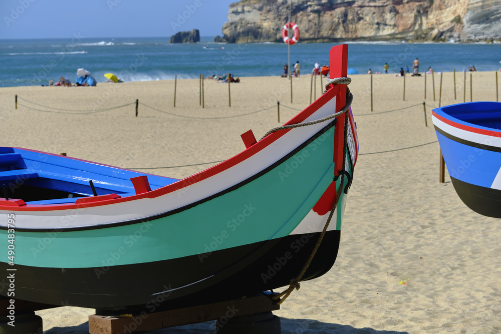 old colorful traditional fishing boats on Nazare Beach, Portugal