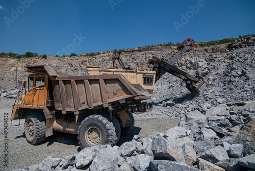 Open pit mining and loading of granite.