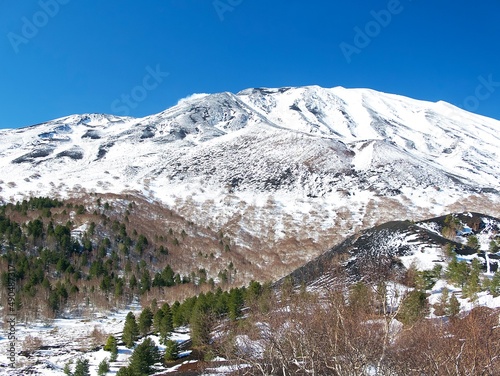 view of volcano Etna covered with snow on a clear sunny day in Sicily