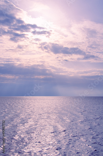 Picturesque seascape background. Pink clouds and blue sea