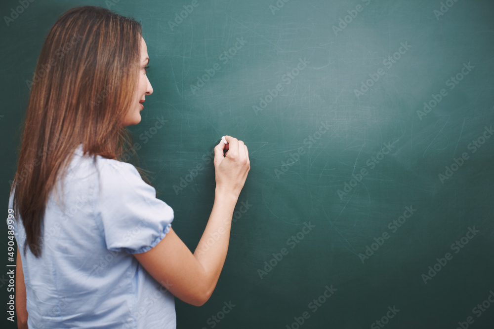 The lesson for today is.... A pretty young teacher writing todays lesson plan on the blackboard.