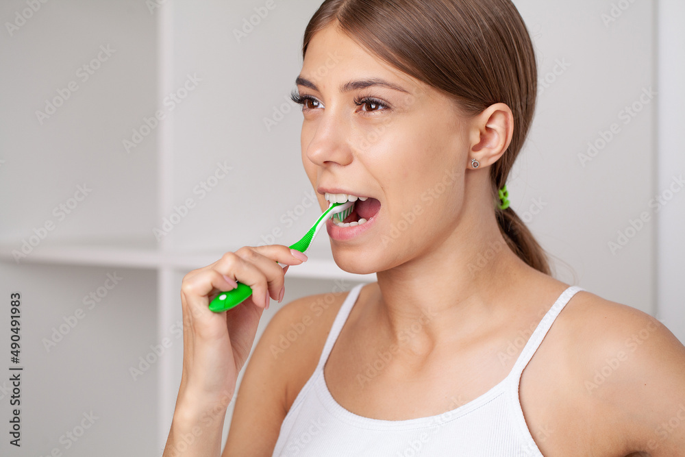 Smiling young woman with healthy teeth holding a tooth brush Smiling young woman with healthy teeth holding a tooth brush