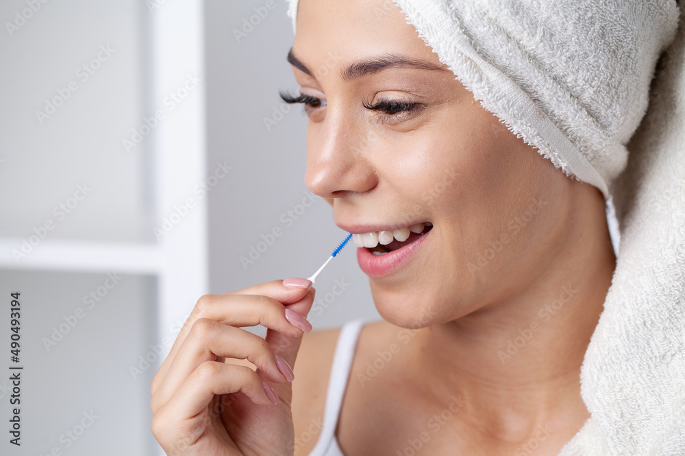 The woman uses brushes to clean the interdental spaces. The woman uses brushes to clean the interdental spaces.