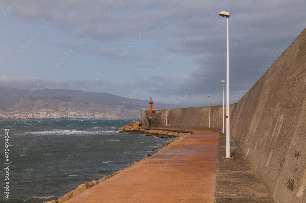 Seawall with lighthouse. Roquetas del Mar, Almeria, Spain