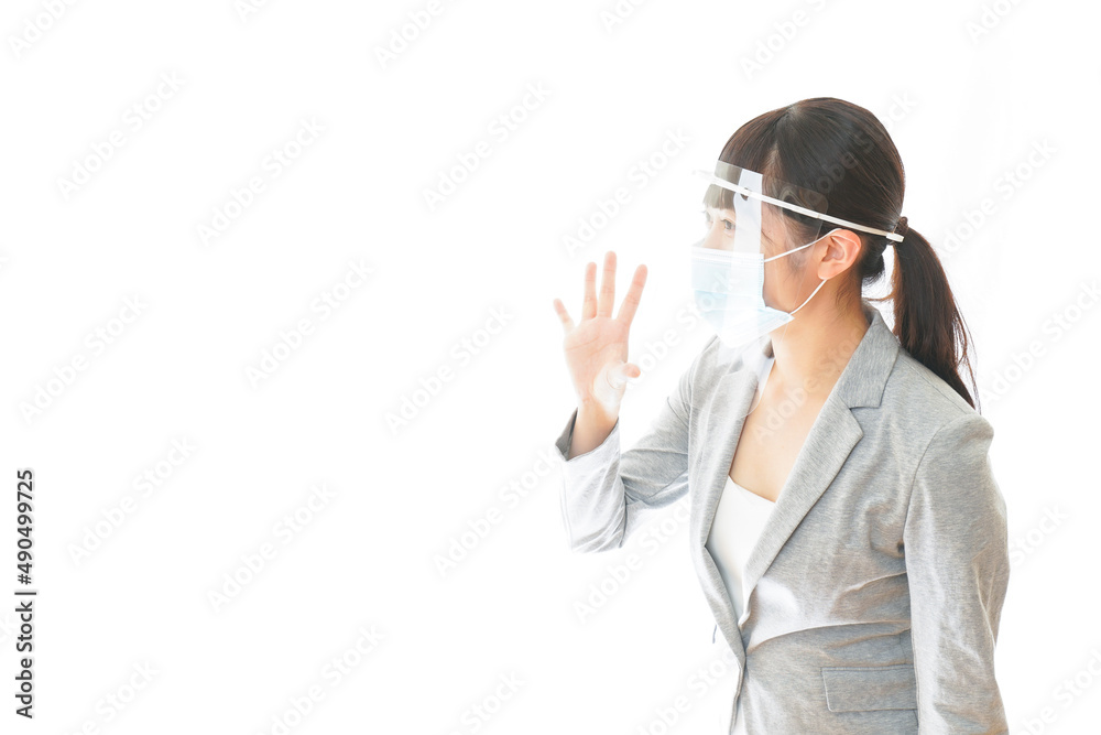 フェイスシールドを装着して接客をするビジネスウーマン