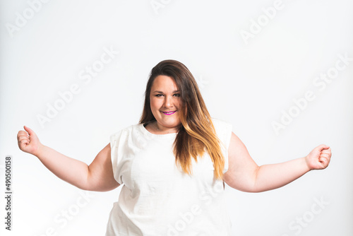 happy plus size model in white t-shirt, with energetic arms on white background, body positive concept, studio shot
